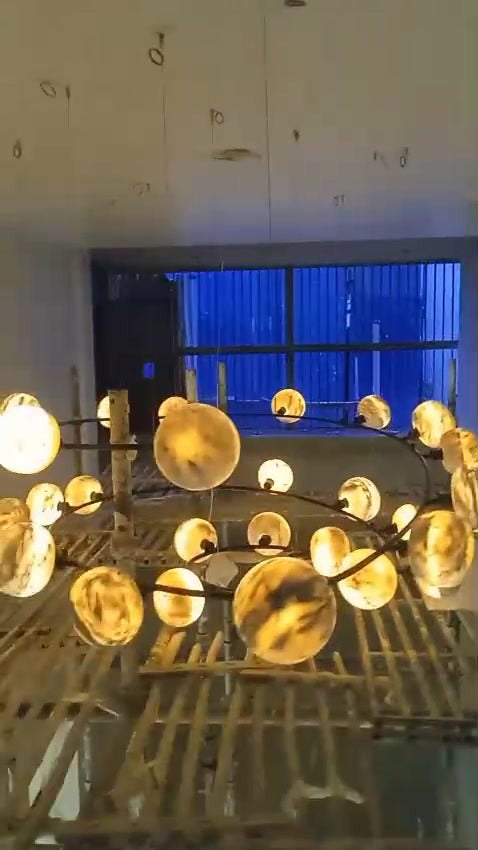 Custom spiral chandelier of glowing marble globes in a stairwell at installation – residence, Defence Colony, New Delhi