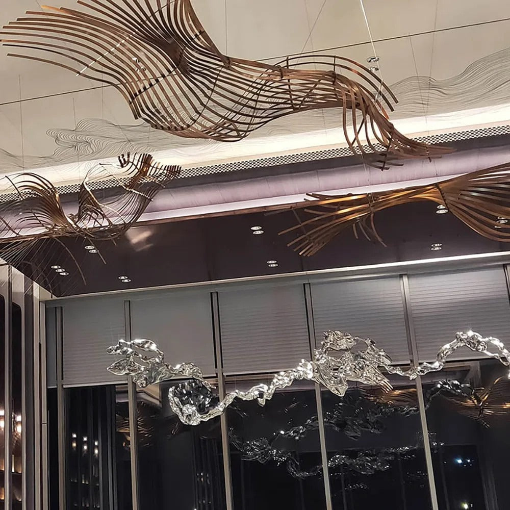 Wide view of flowing antique-bronze curved metal rib-wave sculptures suspended across a high commercial lobby ceiling