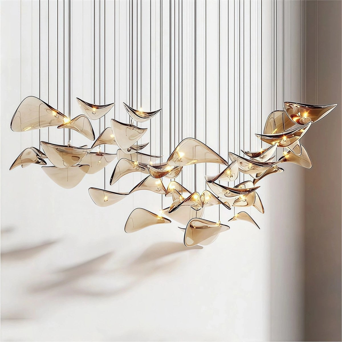 Artistic cluster of curved champagne-amber hand-formed glass wing pendants suspended at staggered heights