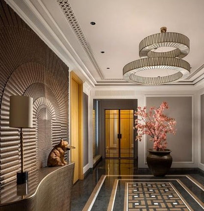 Wide view of a formal entrance foyer featuring the two-tier offset lattice brass ring chandelier suspended from the ceiling