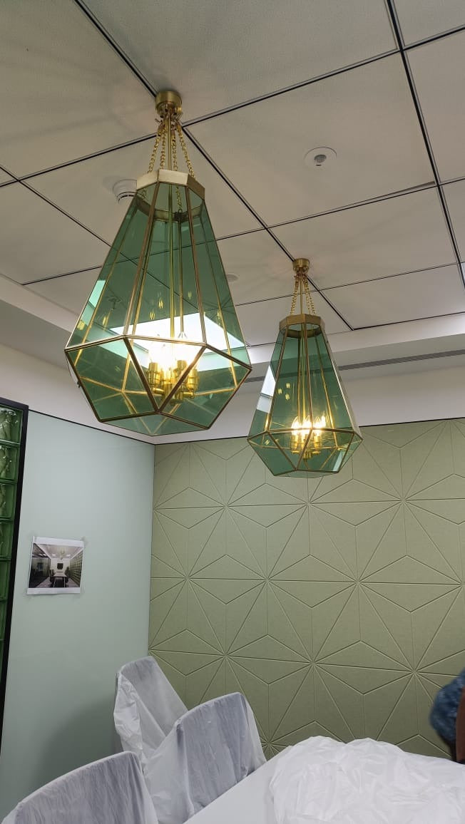 Custom brass and green-tinted glass geometric pendants installed in a corporate meeting room, Hyderabad