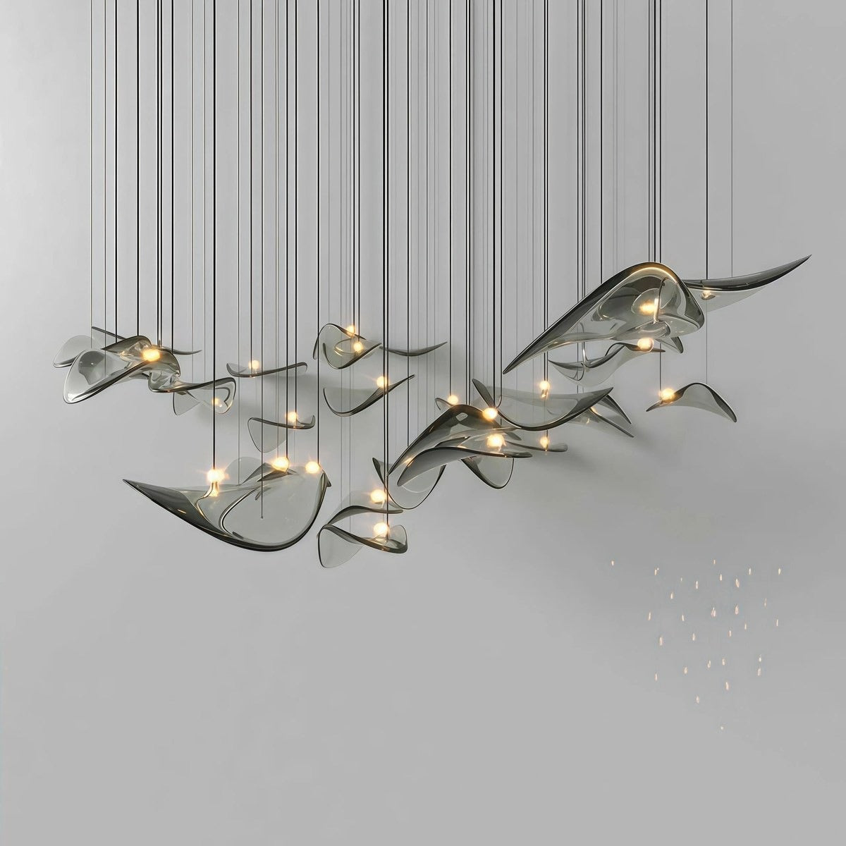 Floating installation of smoked-grey curved glass wing shades with warm central LED points against a neutral wall