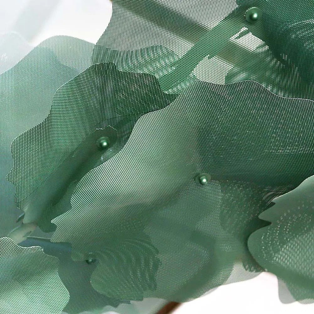 Macro close-up of the fine green perforated metal mesh lotus petals showing scalloped edges and green centre caps