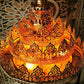 High-angle close-up showing the concentric tiers of flame-shaped floral brass crown crenellations and warm internal bulbs