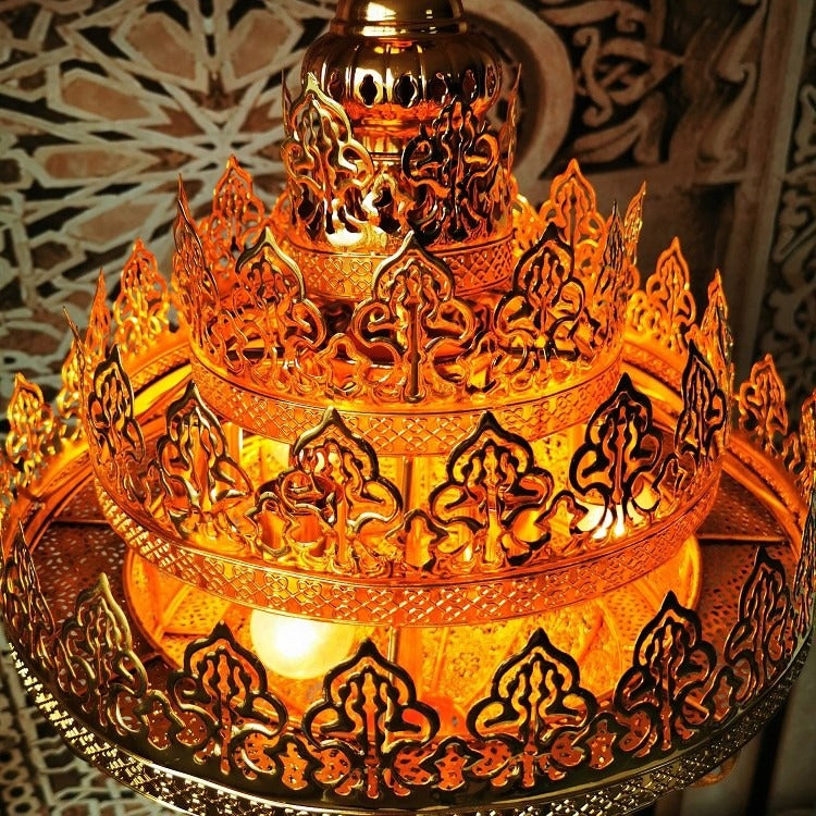 High-angle close-up showing the concentric tiers of flame-shaped floral brass crown crenellations and warm internal bulbs
