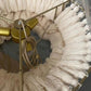 Close-up interior view of the brushed brass ring frame, central lamp holders, braided cord, and hand-tied cream cotton tassels