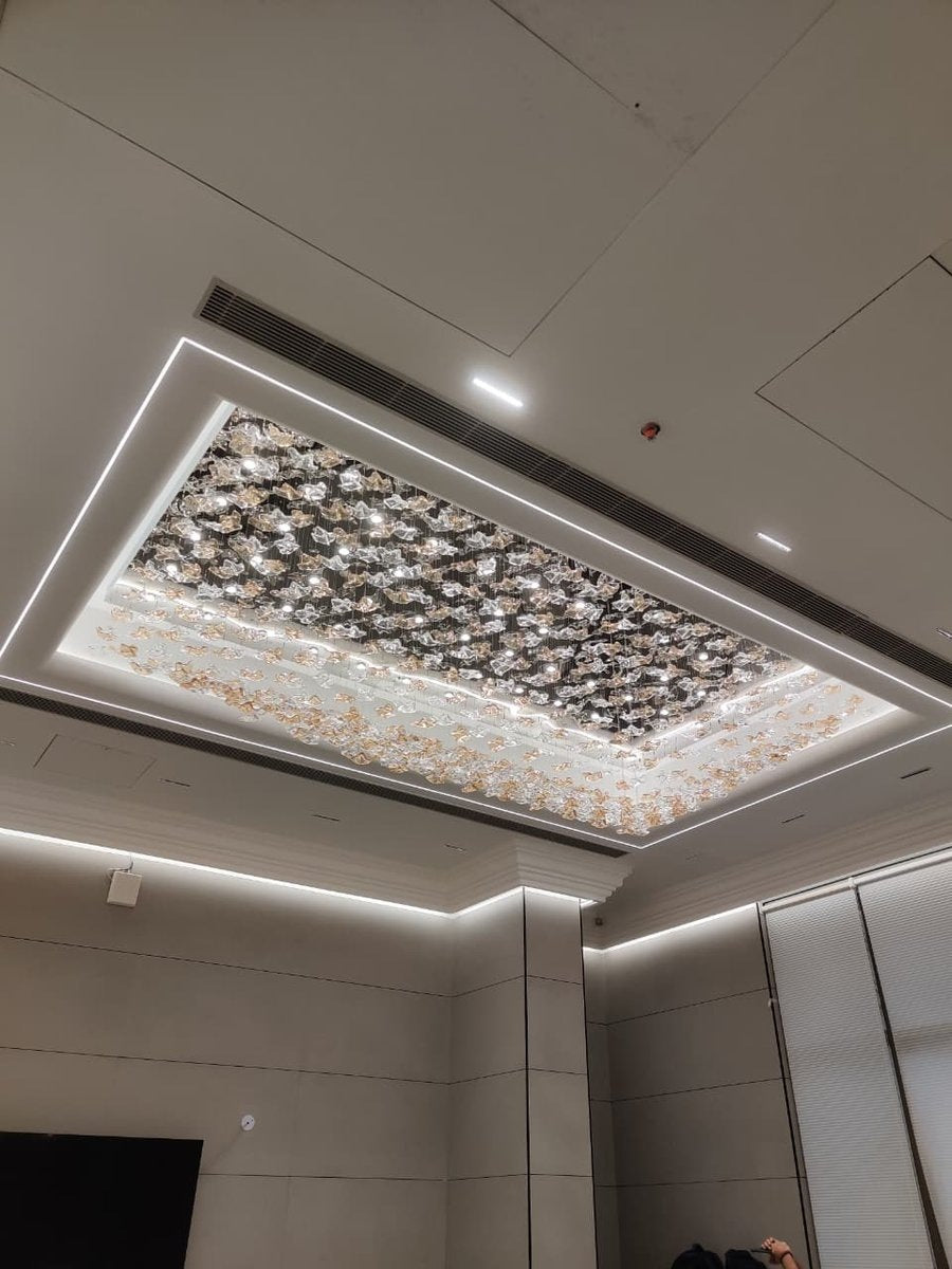 Angled room view showing the rectangular floral glass ceiling chandelier installed inside a recessed ceiling cove