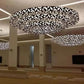 Angled view of tiered concentric geometric ring chandeliers showing triangular dark bronze metalwork and illuminated frosted glass panels