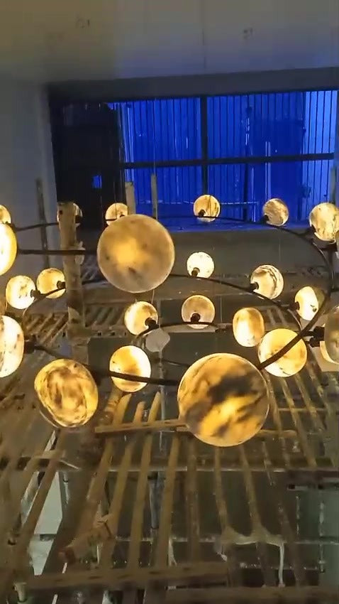 Lit marble globes on the black spiral frame, showing the veining of the stone