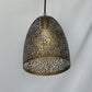 Unlit antique brass perforated dome shade showing branching botanical vein cutouts and a solid lower rim