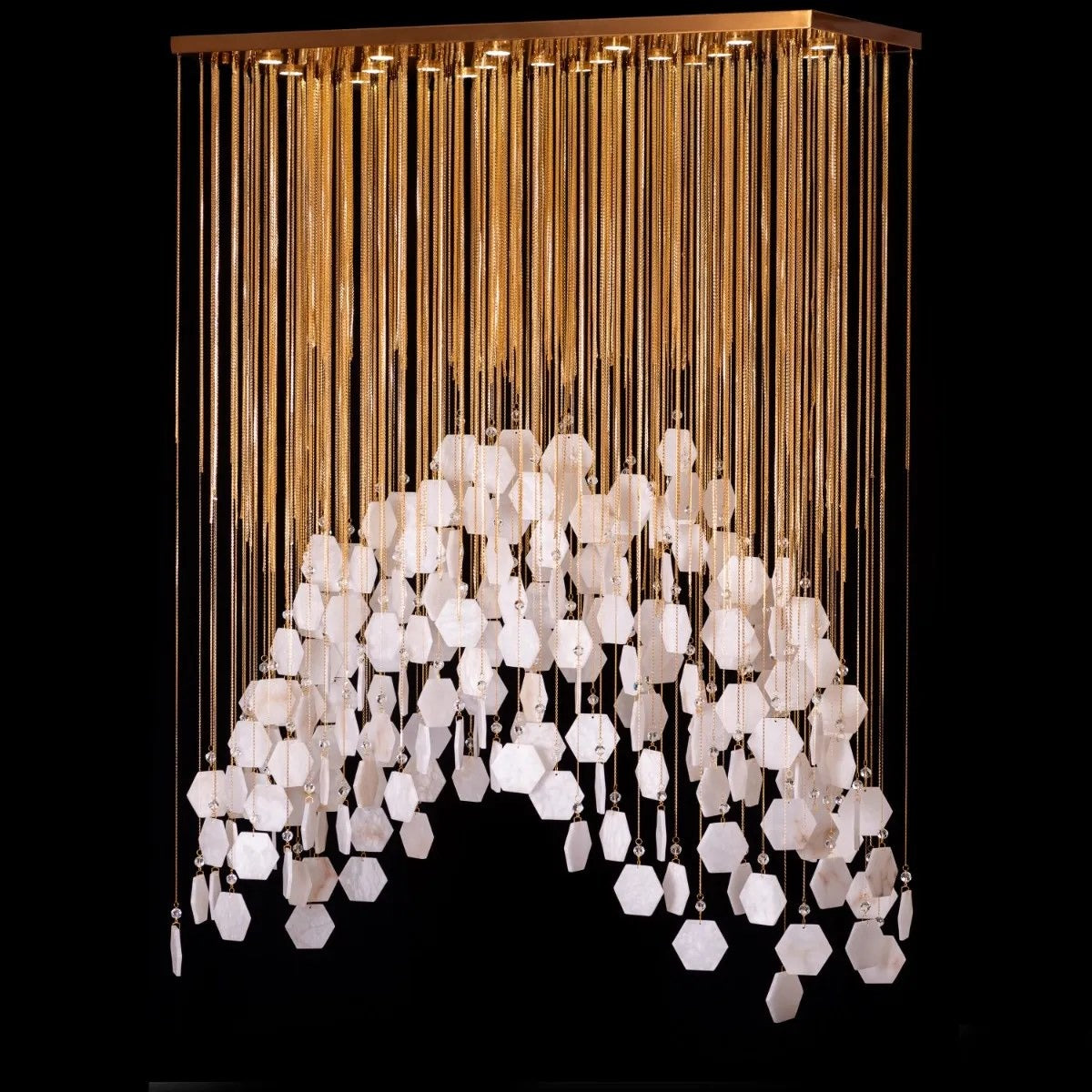 Angled view of the gold chain curtain and white hexagon tile arch chandelier showing recessed canopy downlights