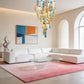 Multi-coloured cast glass bar cluster chandelier hanging above a modern white sectional sofa in a high-ceiling living room