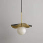 Close-up of the unlit sculpted lotus leaf shade showing the dark bronze top, striated brass underside, and veined white alabaster orb