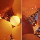 Close-up detail of warm amber and glowing frosted glass globes attached to a heavy brass-toned metal chain