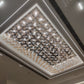 Perspective view of the clear and amber glass blossom cluster chandelier glowing against its mirrored ceiling plate
