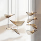 Close-up view of the undulating amber glass wing shades showing the central glowing LED element and slender black stems