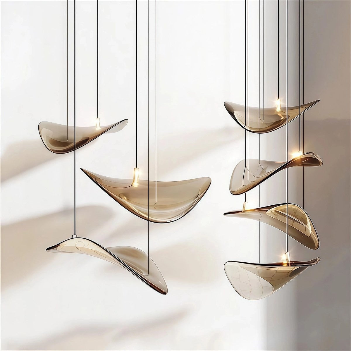 Close-up view of the undulating amber glass wing shades showing the central glowing LED element and slender black stems