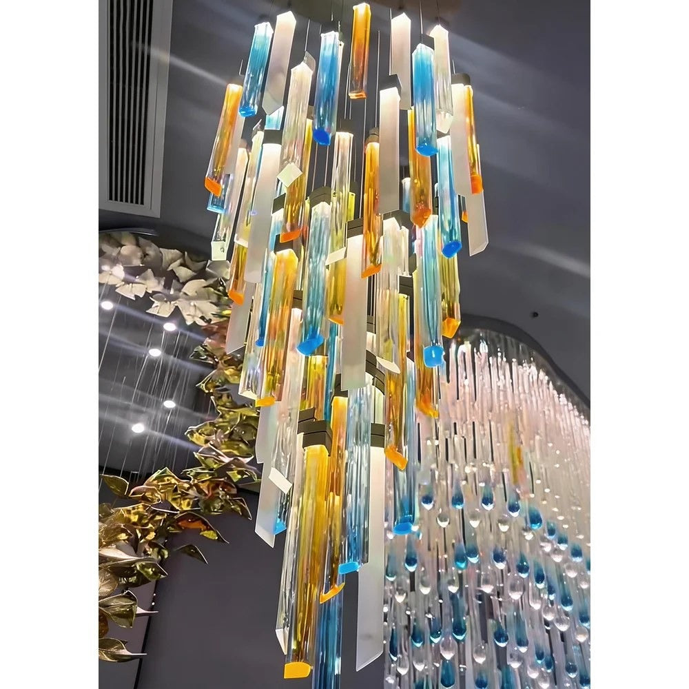 Close-up detail of the bevelled amber, blue, and frosted white rectangular glass columns with dark metal caps