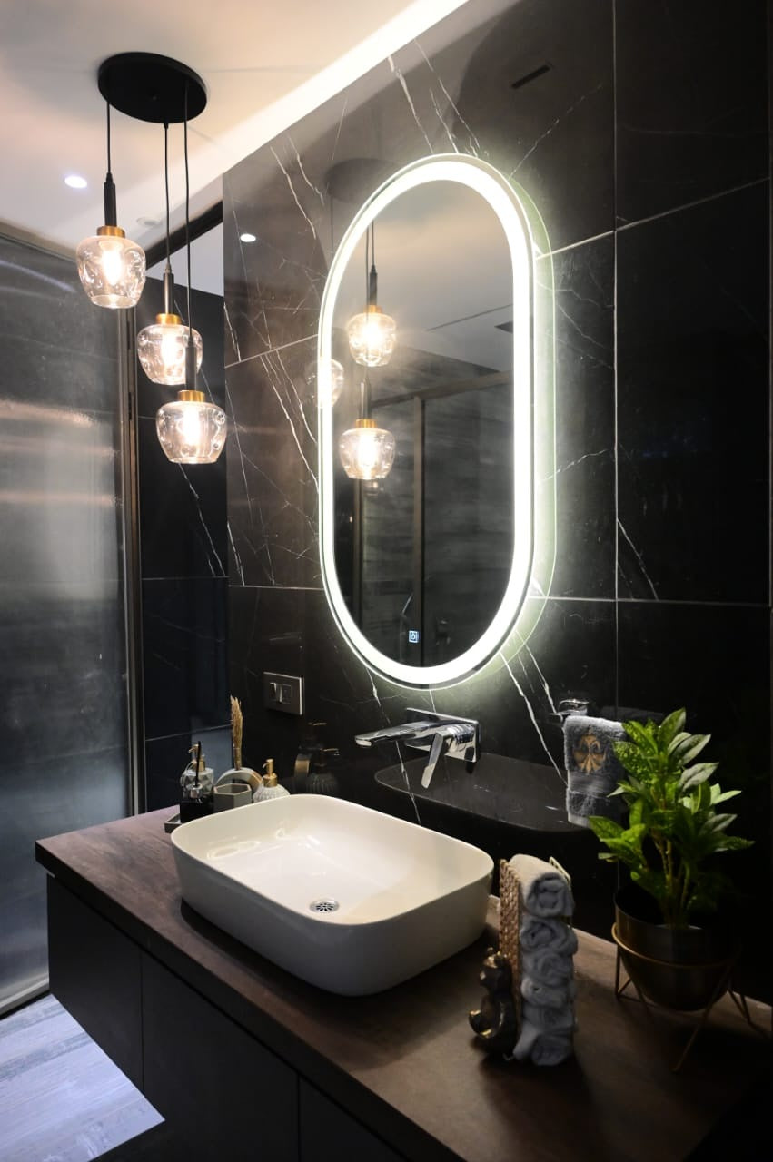 Three-light glass pendant cluster beside the bathroom vanity