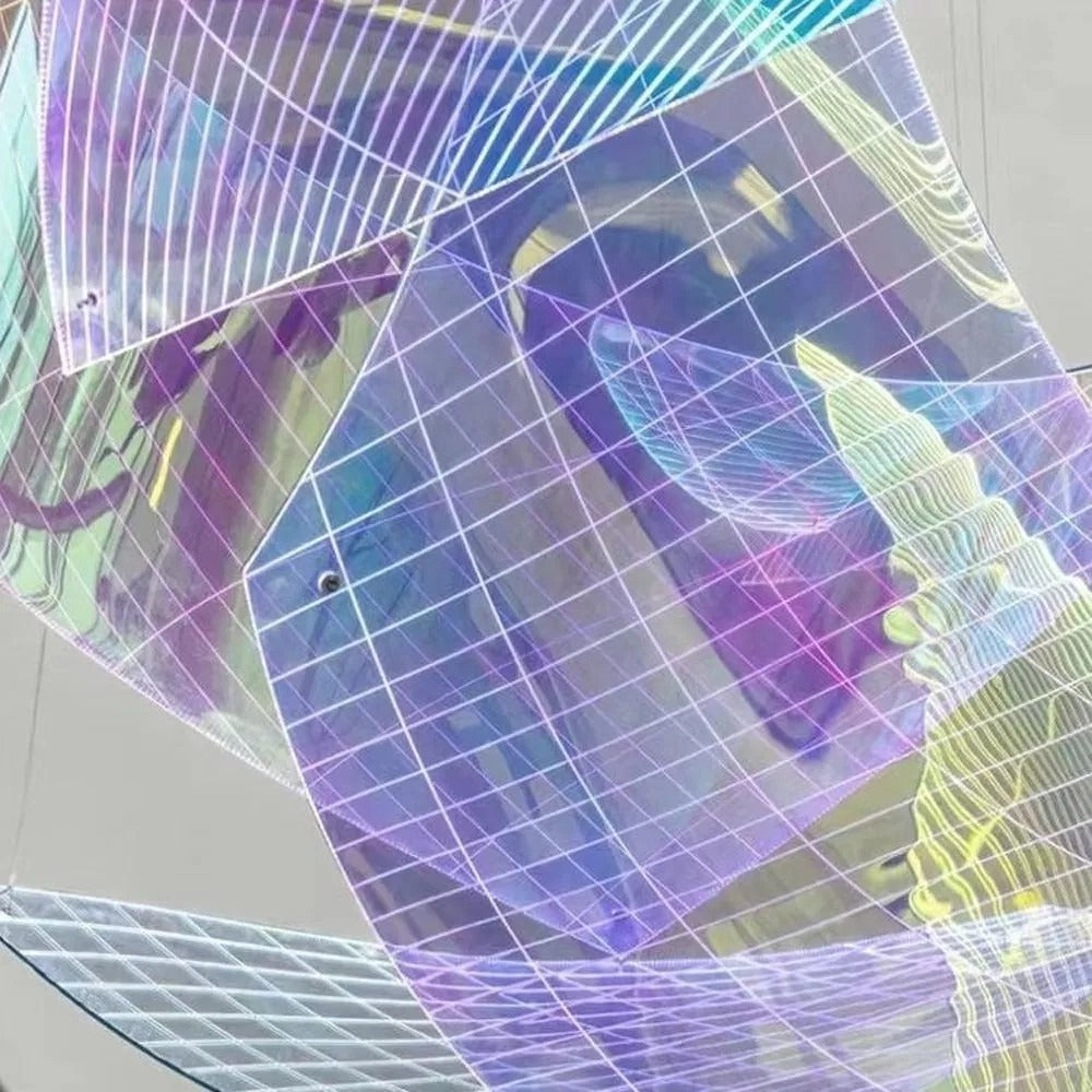 Close-up detail of the translucent purple, cyan, and gold iridescent panels with fine white square wire-mesh grid lines