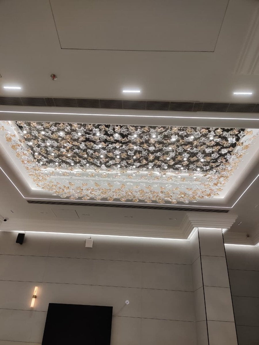 Wide view of the rectangular glass flower ceiling chandelier showing the dense amber perimeter and illuminated core