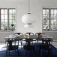 Single two-tier white ribbed silk-paper lantern pendant with wide oval upper globe and open dome lower shade centred over a black dining table