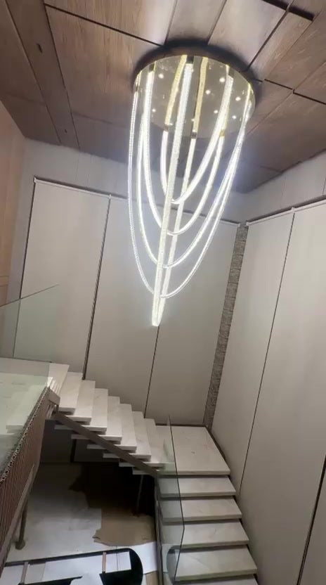 Tall LED-loop chandelier dropping through the stairwell from a round canopy