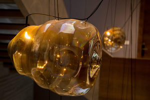 Close-up detail of hand-blown amber glass bubble texture and warm LED glow
