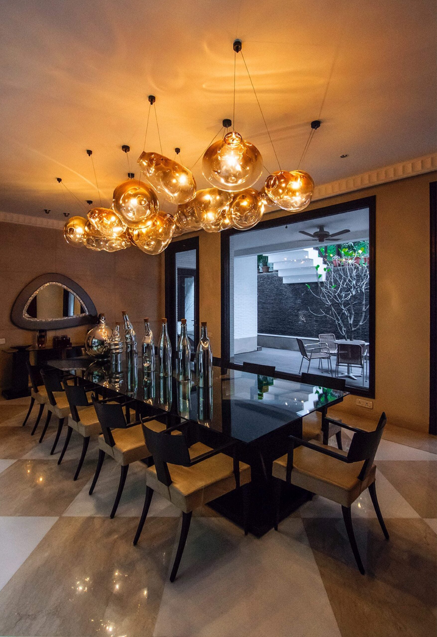 Molten amber glass bubble cluster chandelier installed above a dining table
