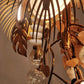 Detail of rattan leaf shades and hand-blown glass drops on the antique brass frame