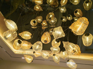 Ribbed glass cluster chandelier glowing under a mirror-finish ceiling in a Delhi home