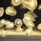 Clear and amber ribbed glass pieces hanging at different heights inside a warm LED cove