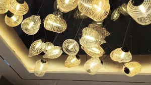 Clear and amber ribbed glass pieces hanging at different heights inside a warm LED cove