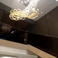 Feather glass spiral chandelier lit above the staircase of a double-height home in Guwahati