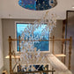 Clear and amber twisted glass ribbon chandelier being installed from scaffolding in the same Guwahati home
