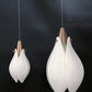 Close-up of the frosted opal glass drop with brushed copper finial