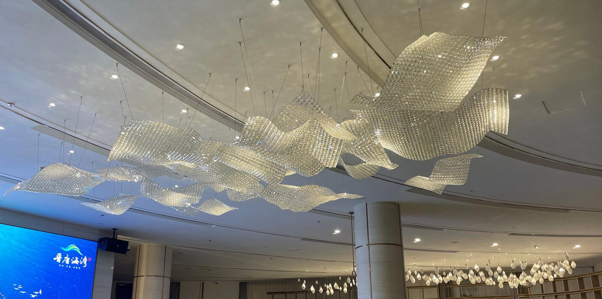 Opaline sequin drift chandelier draped across a grand lobby ceiling