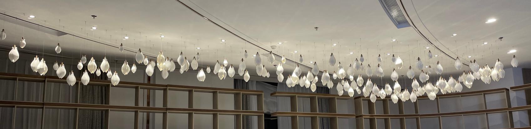 Wide view of the frosted glass drop cascade chandelier across a long ceiling run