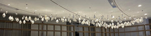 Wide view of the frosted glass drop cascade chandelier across a long ceiling run