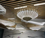 Radiant fan blade pendant chandelier cluster over a retail interior ceiling