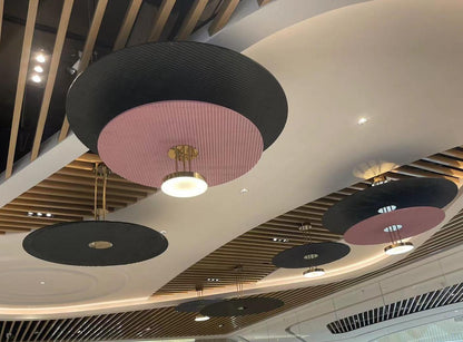 Pleated disc drum pendant chandelier in two-tone finish over a retail ceiling