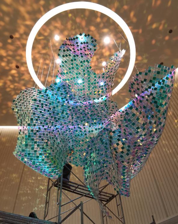 Iridescent mosaic bloom chandelier suspended within a glowing LED halo ring
