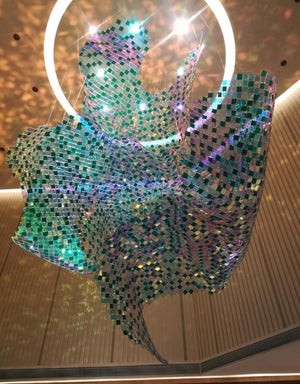 Detail view of the iridescent mosaic tile chandelier catching light