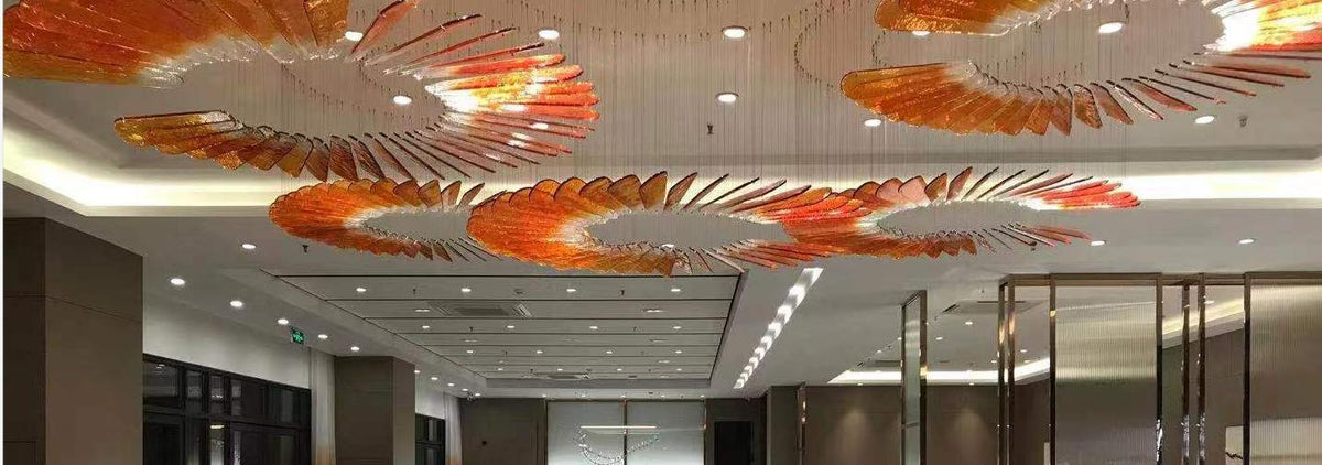 Sunfire feather spiral chandelier with amber glass blades over a lobby ceiling