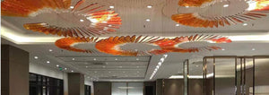 Sunfire feather spiral chandelier with amber glass blades over a lobby ceiling