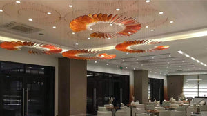 Wide view of the amber glass feather spiral chandelier installation