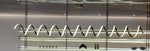 Serpentine spiral LED ribbon chandelier suspended above a bar counter