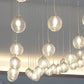 Close-up of ribbed glass orbs in the cascading chandelier catching warm light