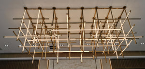 Crosshatch linear beam chandelier installed over a lobby reception area