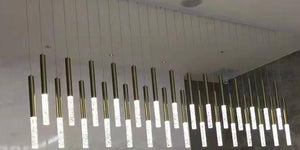 Staggered brass tube cluster chandelier with bubble-textured diffuser tips